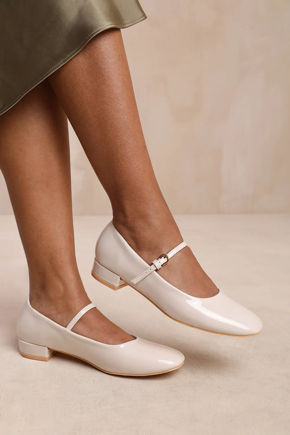 MINSK LOW HEEL WITH STRAP AND BUCKLE DETAIL IN CREAM PATENT